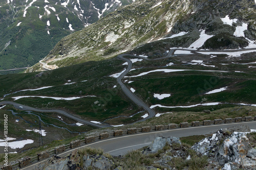 Dangerous panoramic serpentine road high in the Alps between melting snow