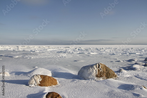 Big rocks under snow and ice with a blue sky in the arctic photo