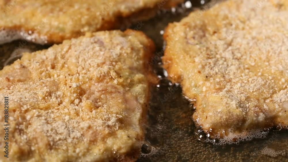 Frying pork meat coated with breadcrumbs in a pan Frying pork meat coated with breadcrumbs in a pan