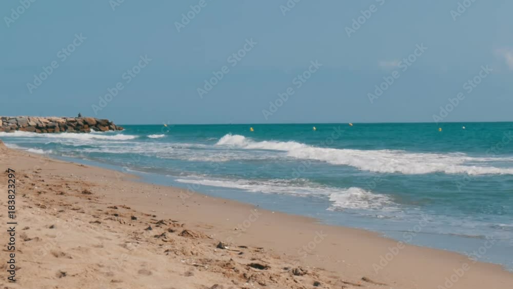 Beach in Spain. Waves of the Mediterranean Sea hit the sand on the beach in Spain Beach in Spain. Waves of the Mediterranean Sea hit the sand on the beach in Spain
