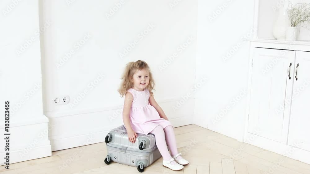 Playful girl sitting on luggage Playful girl sitting on luggage