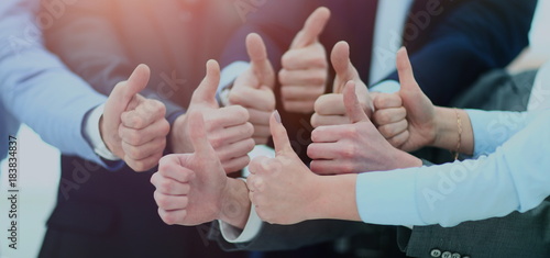 Close-up of business team holding their thumbs up