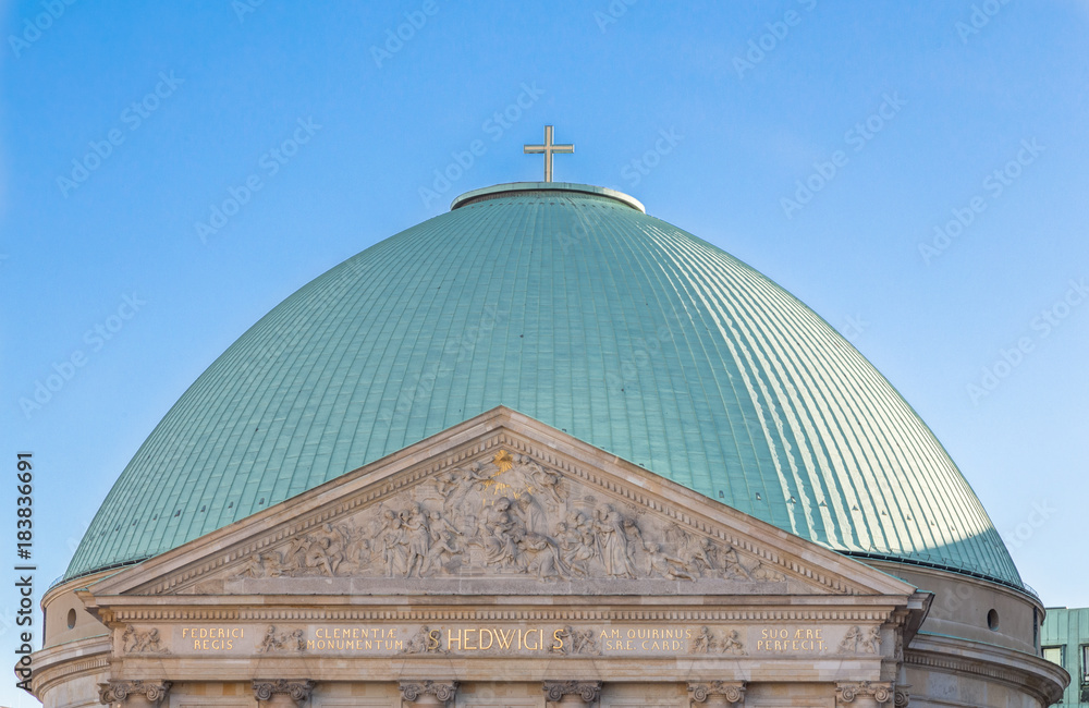 Tableau sur toile Massive green dome with a christian cross on top of Hedwig's Cathedral in Berlin Mitte