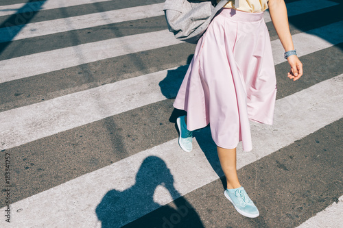 Foto Young woman in a pink skirt and sneakers