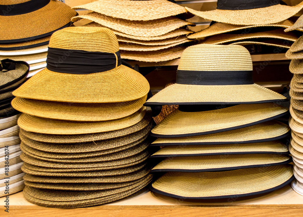 tan colored Panama hats on shelves in a shop