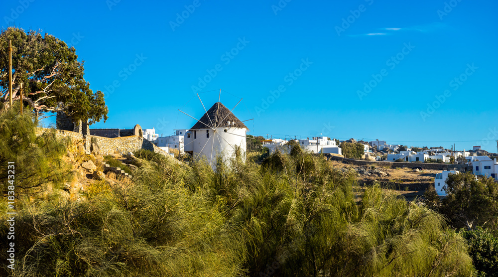 Traditional windmill overlooking Mykonos town at sunny day, Mykonos island, Cyclades, Greece