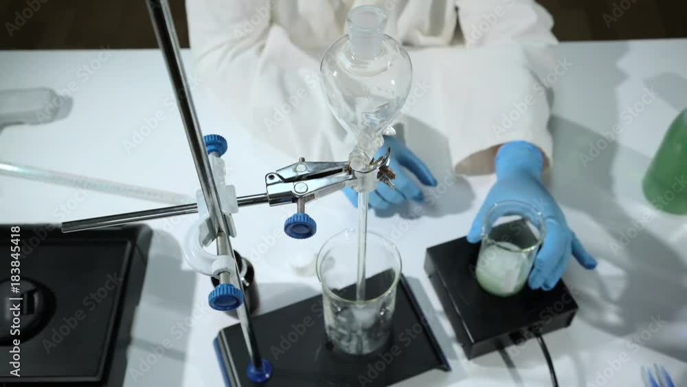 A scientist looks at a sample of a chemical in a laboratory. Woman in the chemical laboratory A scientist looks at a sample of a chemical in a laboratory. Woman in the chemical laboratory