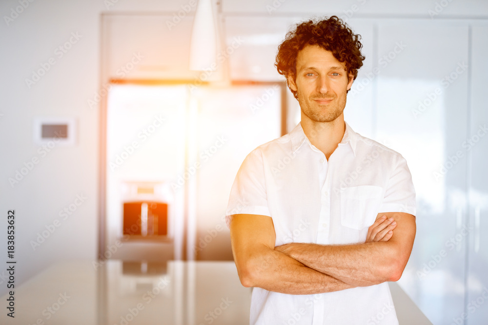 Portrait of a smart young man standing in kitchen Portrait of a smart young man standing in kitchen