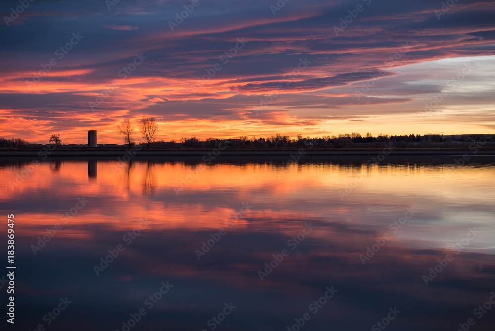 Purple and orange sunset reflected over the reservoir 