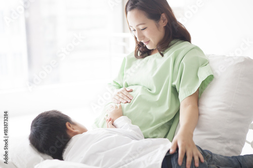 A son touches his mother's belly