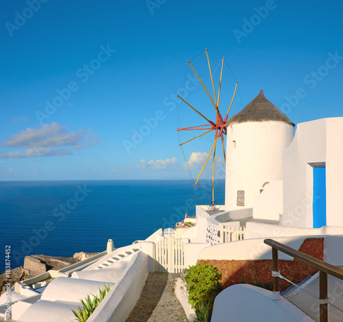 Traditional windmill in Oia village on a sunny day, panoramic image.