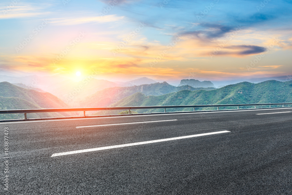 Fototapeta premium Asphalt highway and mountain nature landscape at sunset