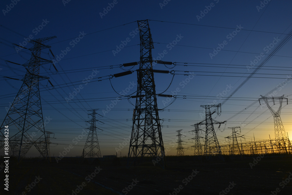 Fototapeta premium The silhouette of the evening electricity transmission pylon