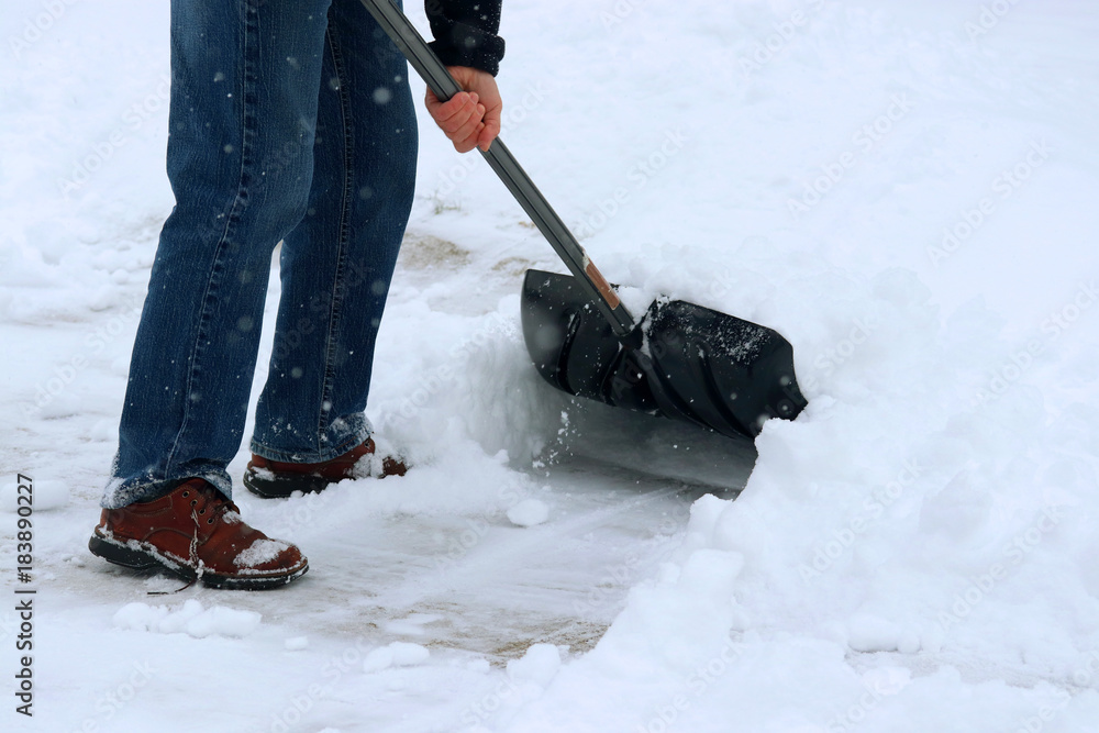 Winter snowy day background. Man shoveling snow on driveway during a heavy  snowfall. Close up composition. Stock Photo | Adobe Stock