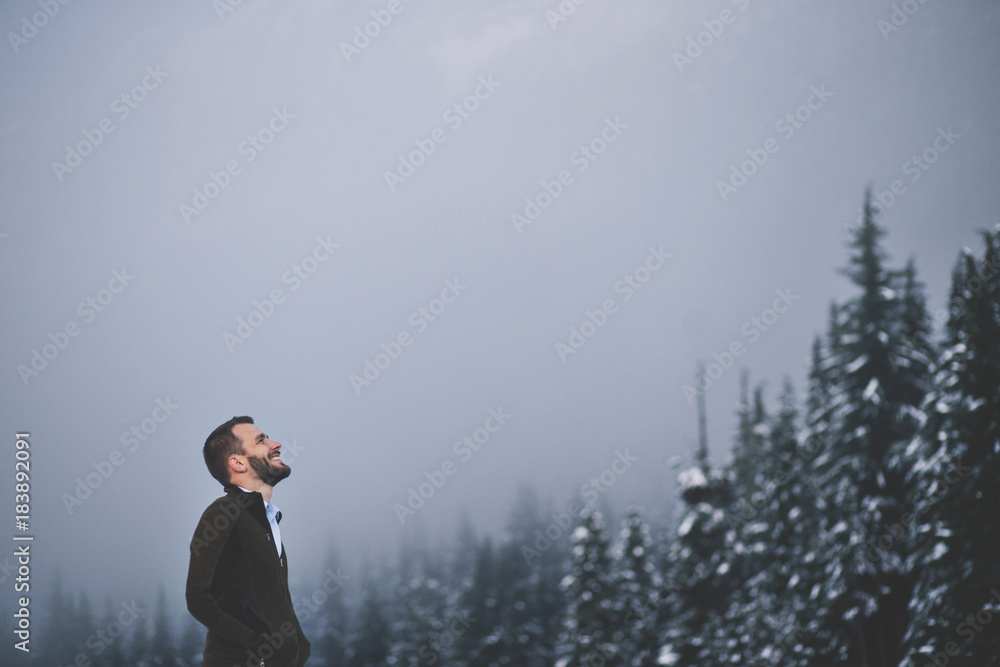 Hiker contemplating in front of foggy forest landscape Hiker contemplating in front of foggy forest landscape