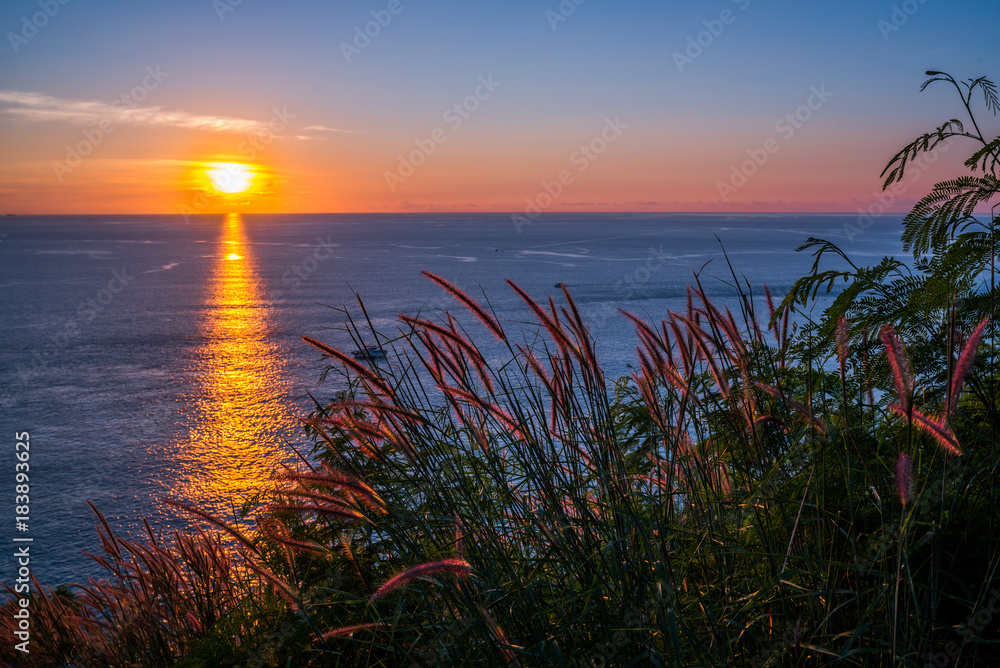 Grass Field in front of the sunset at Leam PromThep Cape in Phuket, Amazing Thailand