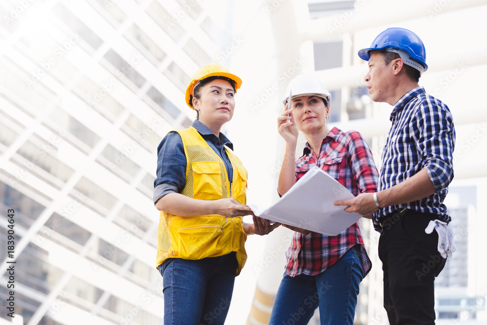 Engineers man and woman working on plan building construction in city Engineers man and woman working on plan building construction in city