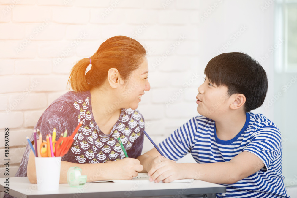 Asian boy with mother teaching and learning your homework at home Asian boy with mother teaching and learning your homework at home