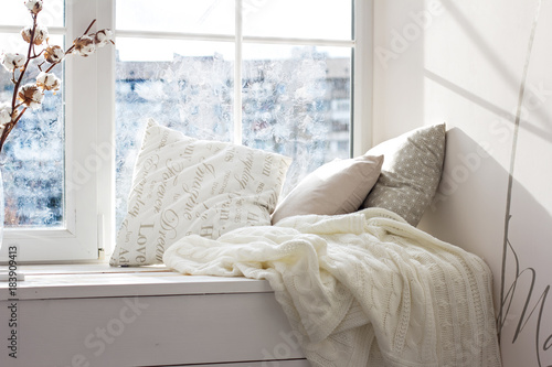 cushions and a knitted plaid on the windowsill. photo