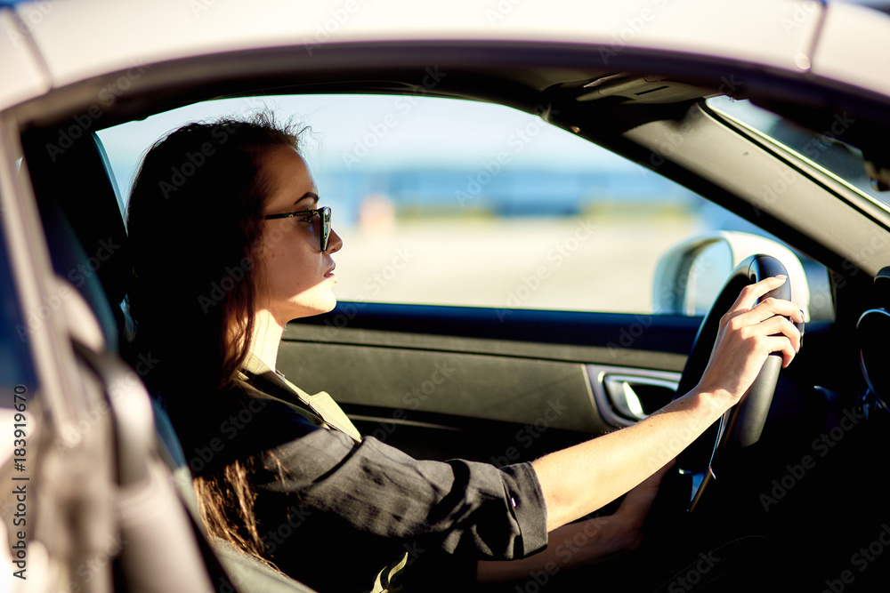 beautiful business woman in sunglasses and business suit at sunset on the background of an expensive car beautiful business woman in sunglasses and business suit at sunset on the background of an expensive car
