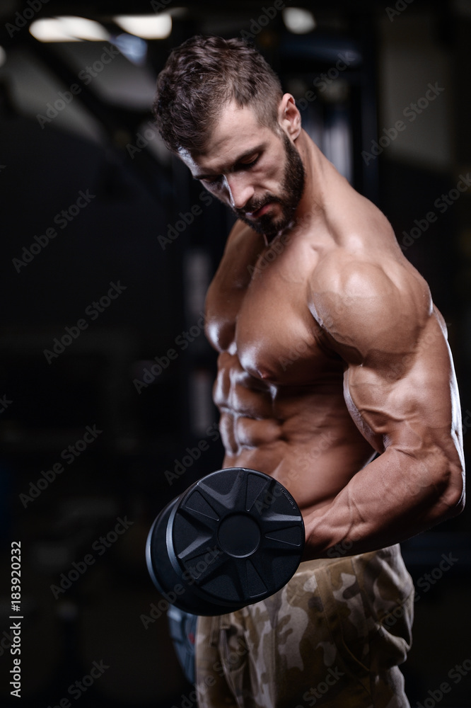 Fototapeta premium sexy strong bodybuilder athletic men pumping up muscles with dumbbells