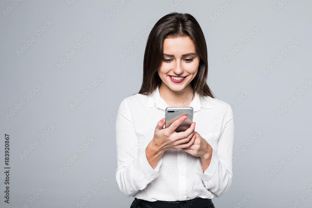 Business woman texting on her cell phone over a white background Business woman texting on her cell phone over a white background