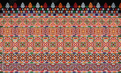 CLOSE UP THE SEAMLESS PATTERN OF COLORFUL CLOTHES. THE HANDMADE EMBROIDERY DID BY HILL TRIBE WOMEN.