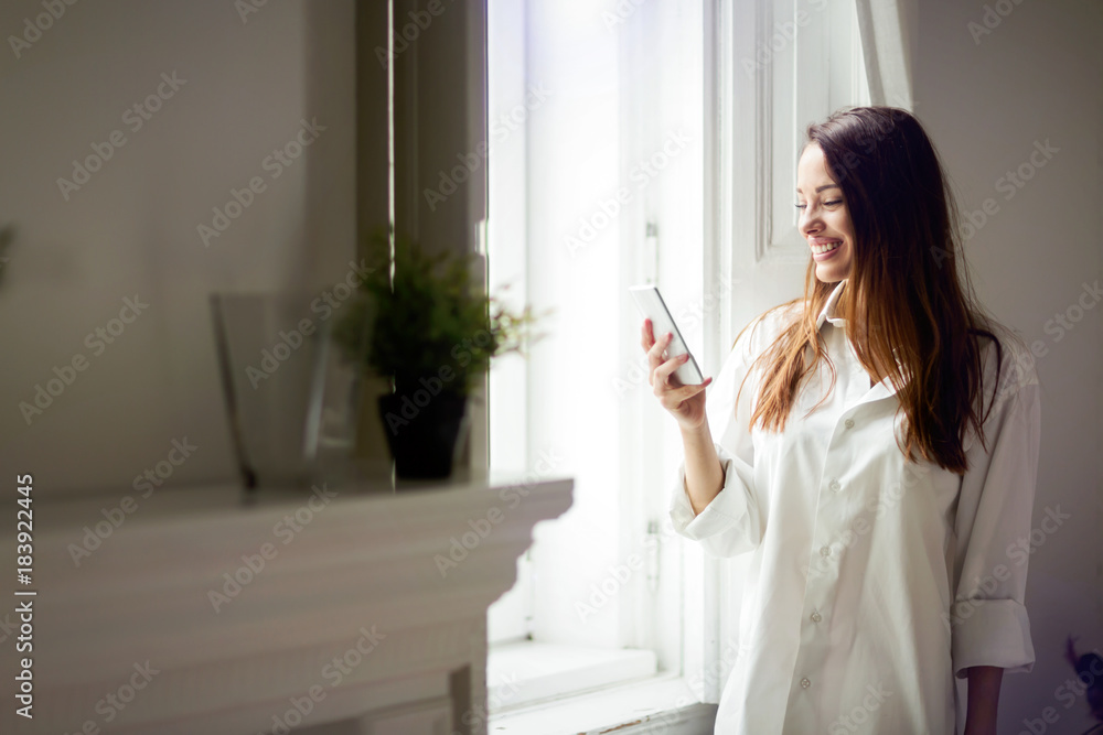 Beautiful woman using phone in her room
