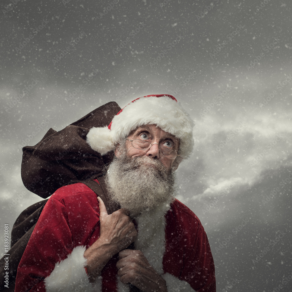 Santa Claus carrying Christmas gifts - obrazy, fototapety, plakaty 