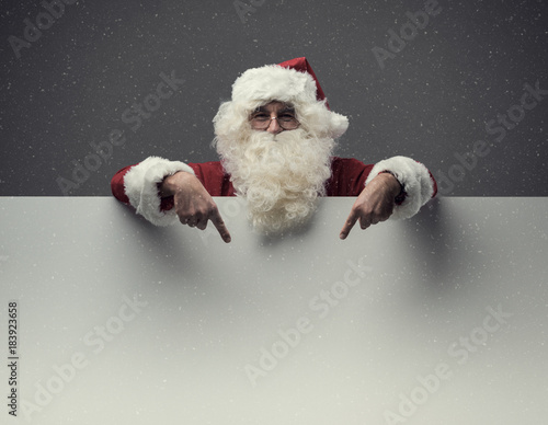 Santa Claus pointing at blank sign