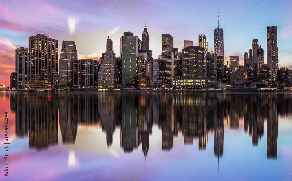 NEW YORK, UNITED STATES OF AMERICA - APRIL 28, 2017: New York City Manhattan skyline panorama with skyscrapers building in at dusk illuminated with lights at sunset