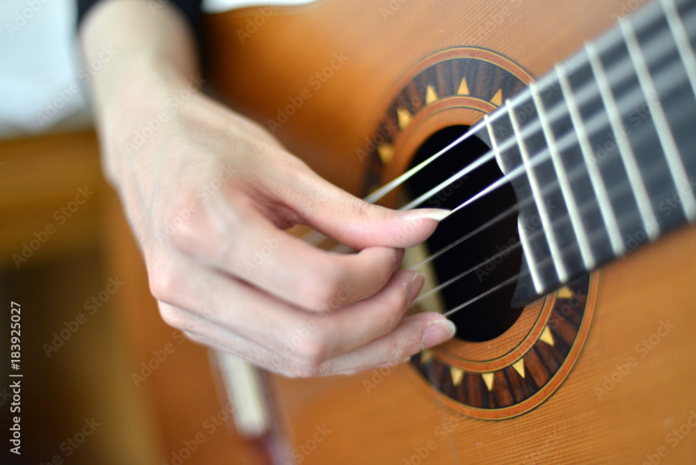 Fototapeta premium Female hand playing on electric guitar close up.