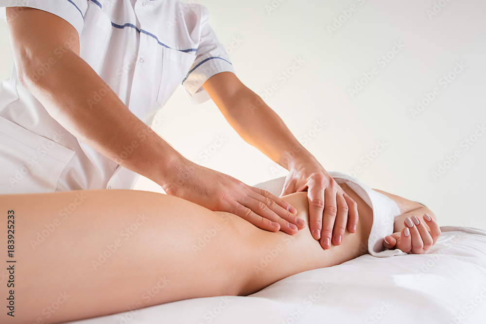 Detail of hands massaging human calf muscle. Detail of hands massaging human calf muscle.