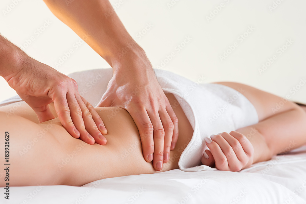 Detail of hands massaging human calf muscle. Detail of hands massaging human calf muscle.