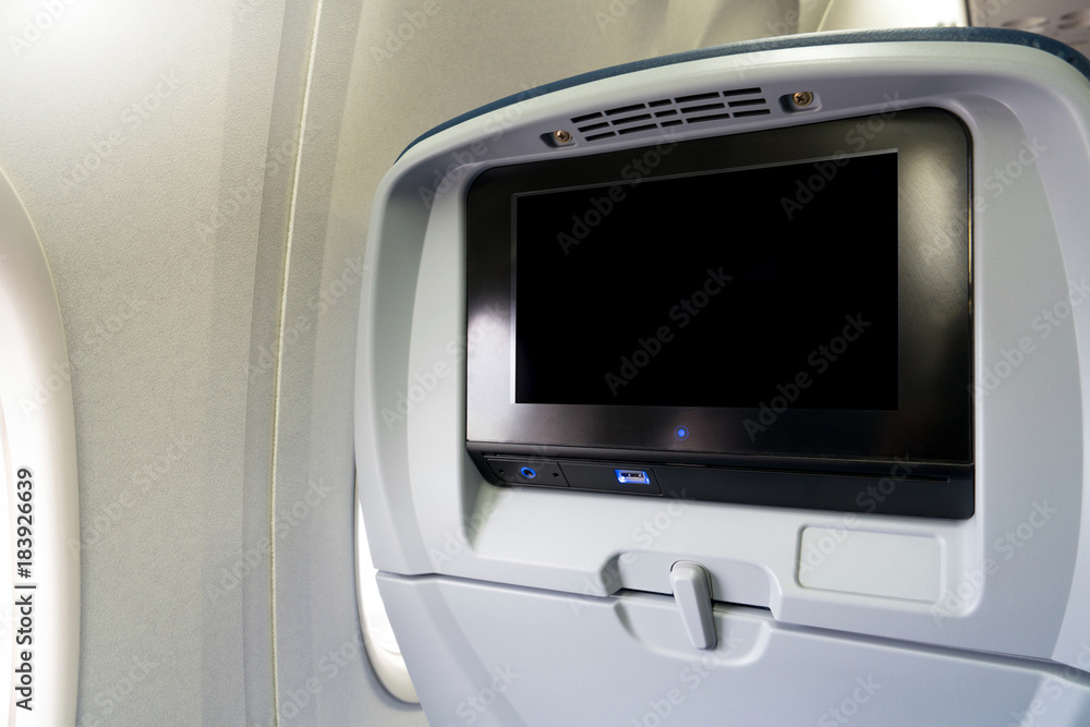 Close-up LCD monitor screen rear seat on the plane technology for entertainment. Airplane seats with screen monitor service for passenger entertainment on board. Close-up LCD monitor screen rear seat on the plane technology for entertainment. Airplane seats with screen monitor service for passenger entertainment on board.