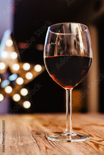 a glass of wine on the background of holiday lights