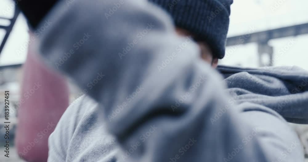 Close up of the handsome caucasian man in a cap and with a beard boxing to the camera on the cold misty day. Outdoor. Portrait Close up of the handsome caucasian man in a cap and with a beard boxing to the camera on the cold misty day. Outdoor. Portrait