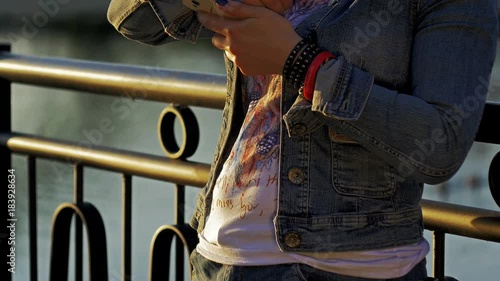 Pretty happy woman using smartphone in city park photo