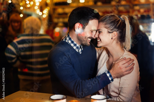 Happy couple kissing at bar and having date