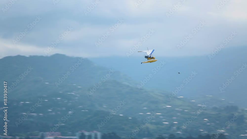 Hang-glider flying high in the sky and landing at seaside, active tourism, sport Hang-glider flying high in the sky and landing at seaside, active tourism, sport