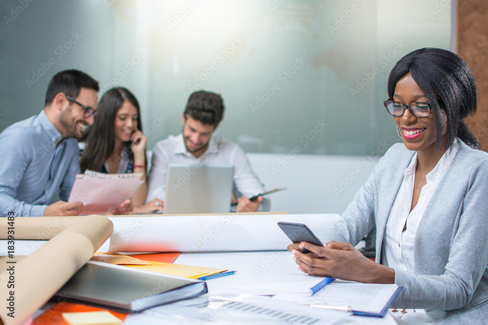 Smiling business woman using phone at office desk. Smiling business woman using phone at office desk.