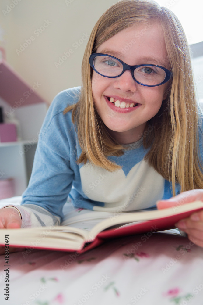 Young Girl Lying On Bed Reading Book Stock Photo Adobe Stock