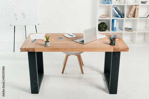 workplace with laptop and office supplies in white office © LIGHTFIELD STUDIOS