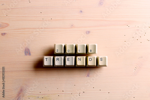 Trends 2018 concept on computer keyboard keys buttons on a wooden background