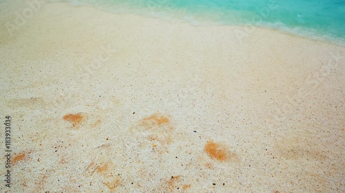 Inspirational wide slow motion turquoise waters lapping the pristine sands of  Marble Beach in Greece, also known as Saliara. The beach has pearl-like white pebbles and deep blue waters photo