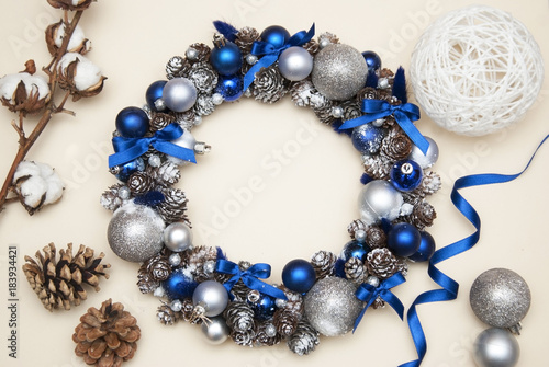 Cristmas Wreath with Fir branches, blue and Silver Globes or Balls. Pinecones and cotton Flowers.
