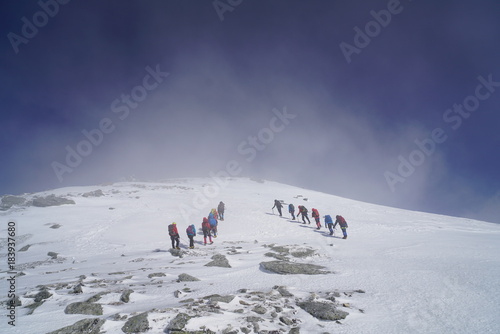 厳冬の中央アルプス木曽駒ヶ岳。地吹雪の中を登る登山者