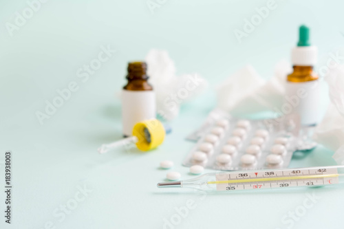 flu treatments. Spray for the nose or a pill to treat colds and gripes. Glass Bottle with medicines and paper handkerchiefs on blue background. Copy space for text. mockup, Top view. flat lay. photo