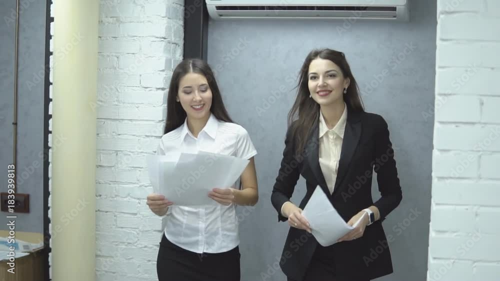 The work is done. Happy positive workers of large business center - two young girlin suit happily toss up papers rejoicing at the completed work, slow motion The work is done. Happy positive workers of large business center - two young girlin suit happily toss up papers rejoicing at the completed work, slow motion