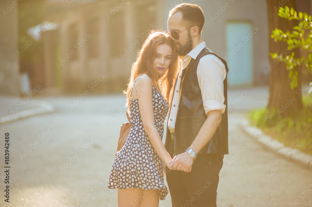 Couple in love having romantic tender moments at sunset in the city. Young lovers having tender moments in summer vacation. Love concept. Soft focus